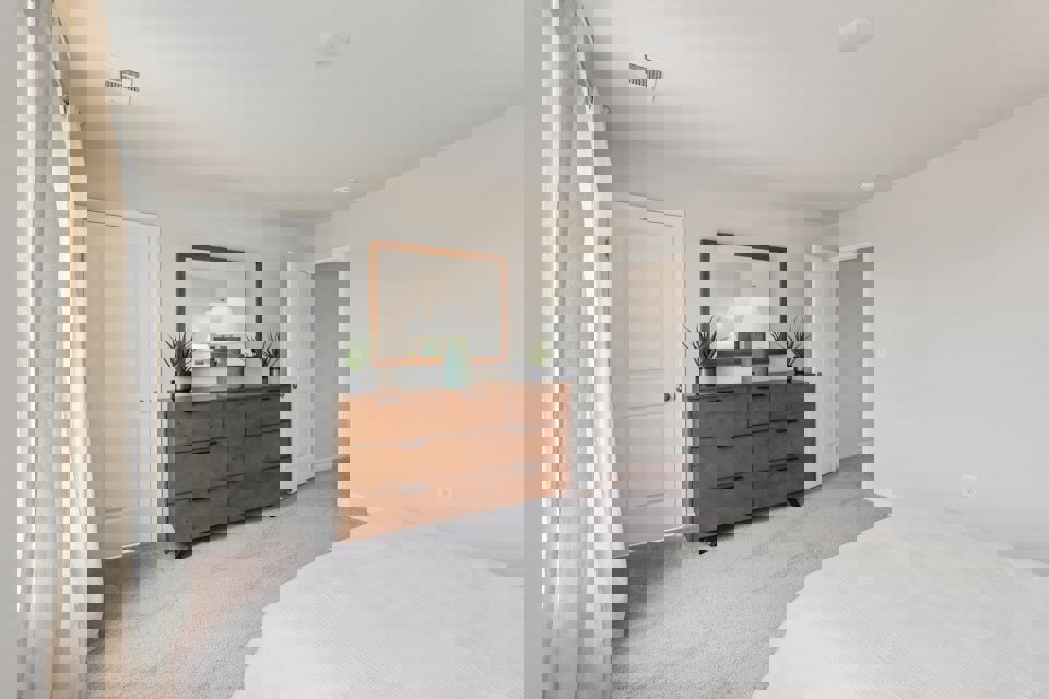 A bedroom with a bed and a dresser.