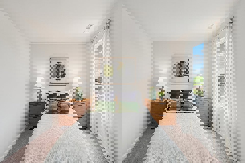 A bedroom with a bed and lamps.