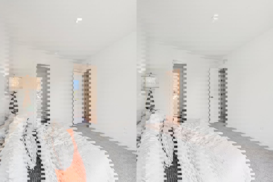 A bedroom with a bed and a lamp.