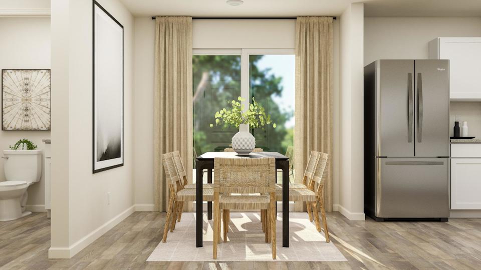 A kitchen with a dining table and chairs.