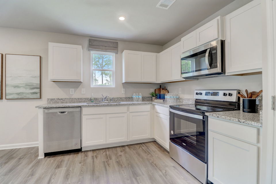 A kitchen with white cabinets.