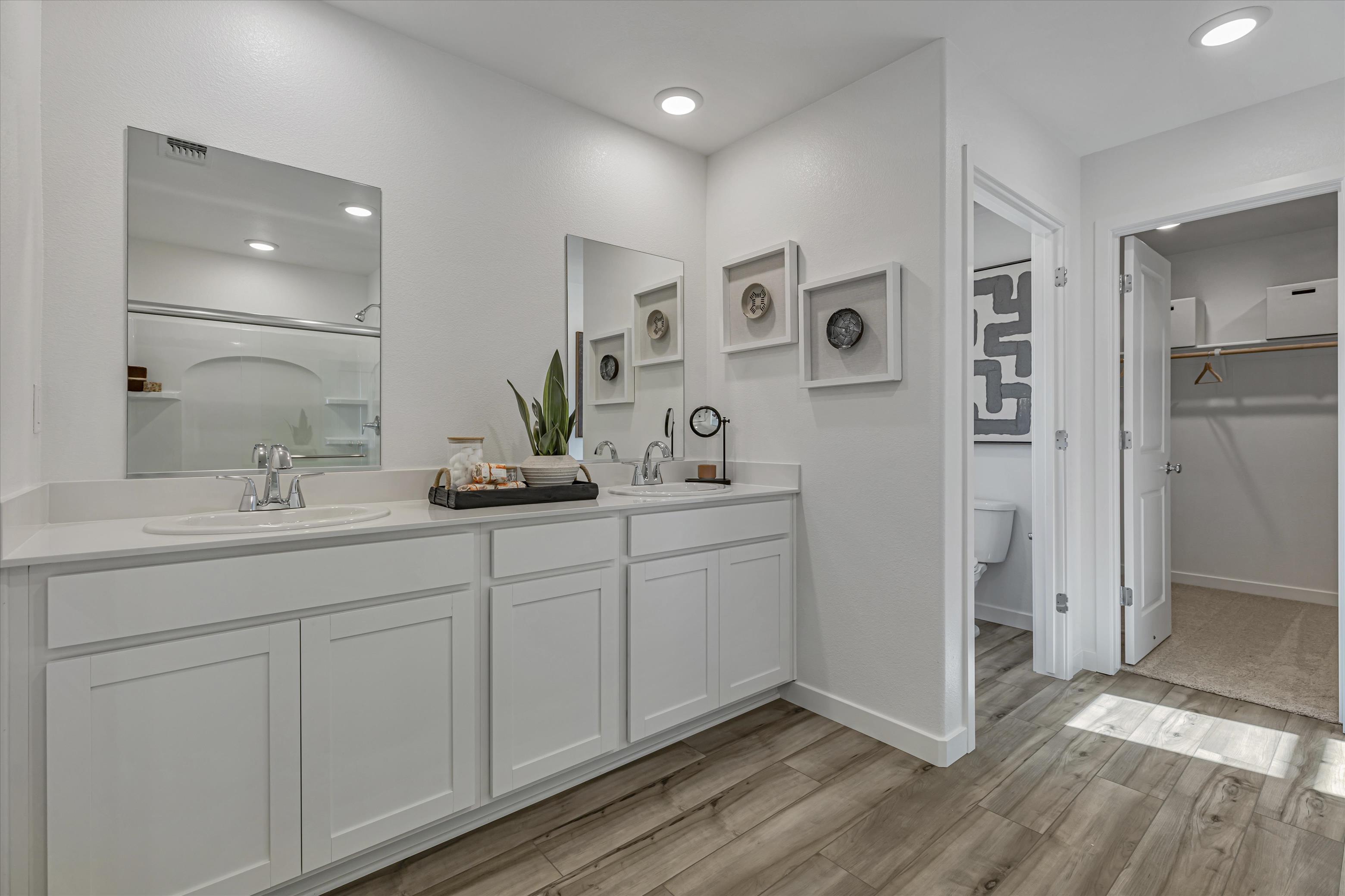 A bathroom with white cabinets.